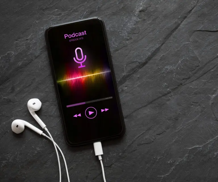 Smartphone mit aktiver Podcast-App und Kopfhörern
