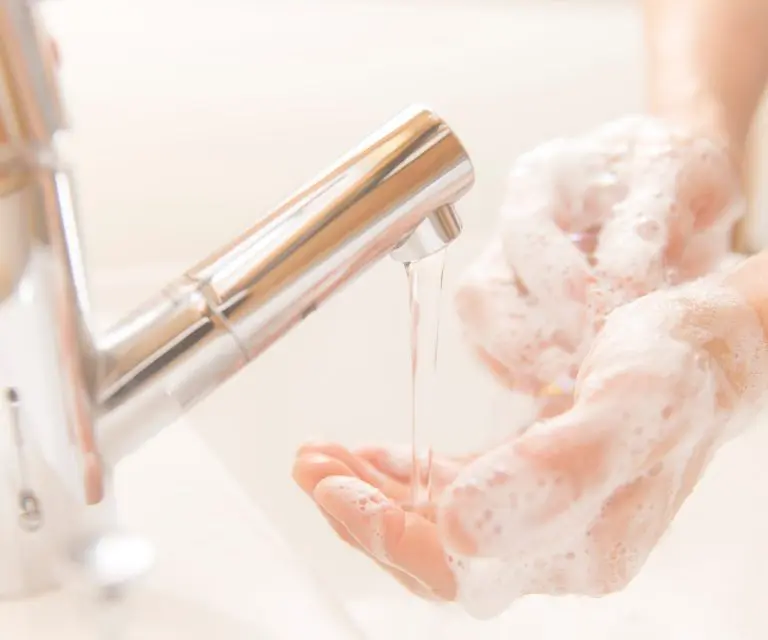 Person wäscht sich die Hände mit Seifenschaum