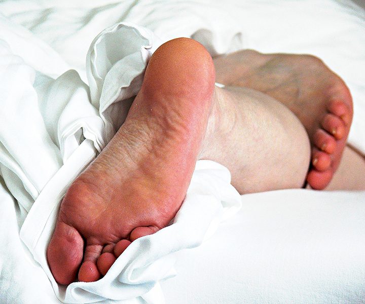 Fußsohlen einer Person, die im Bett liegt